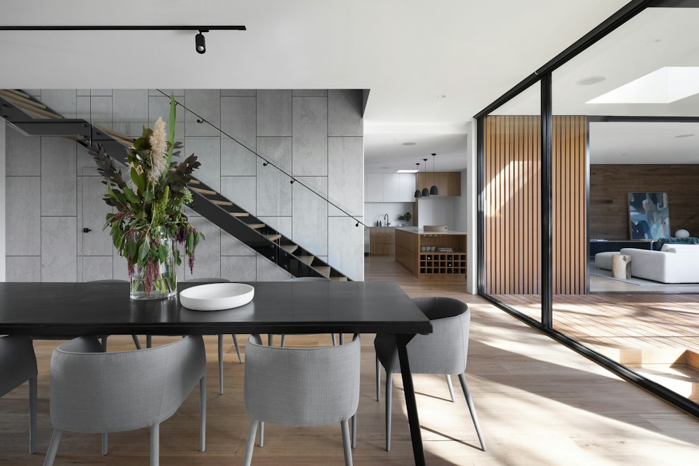 Interior ruang makan dengan meja hitam dan material kayu
